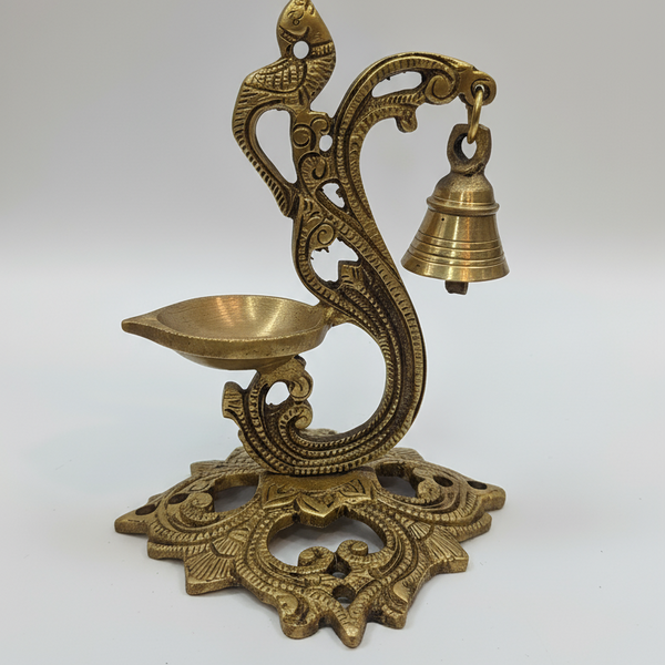 Decorative brass lamp with bell on a white background
